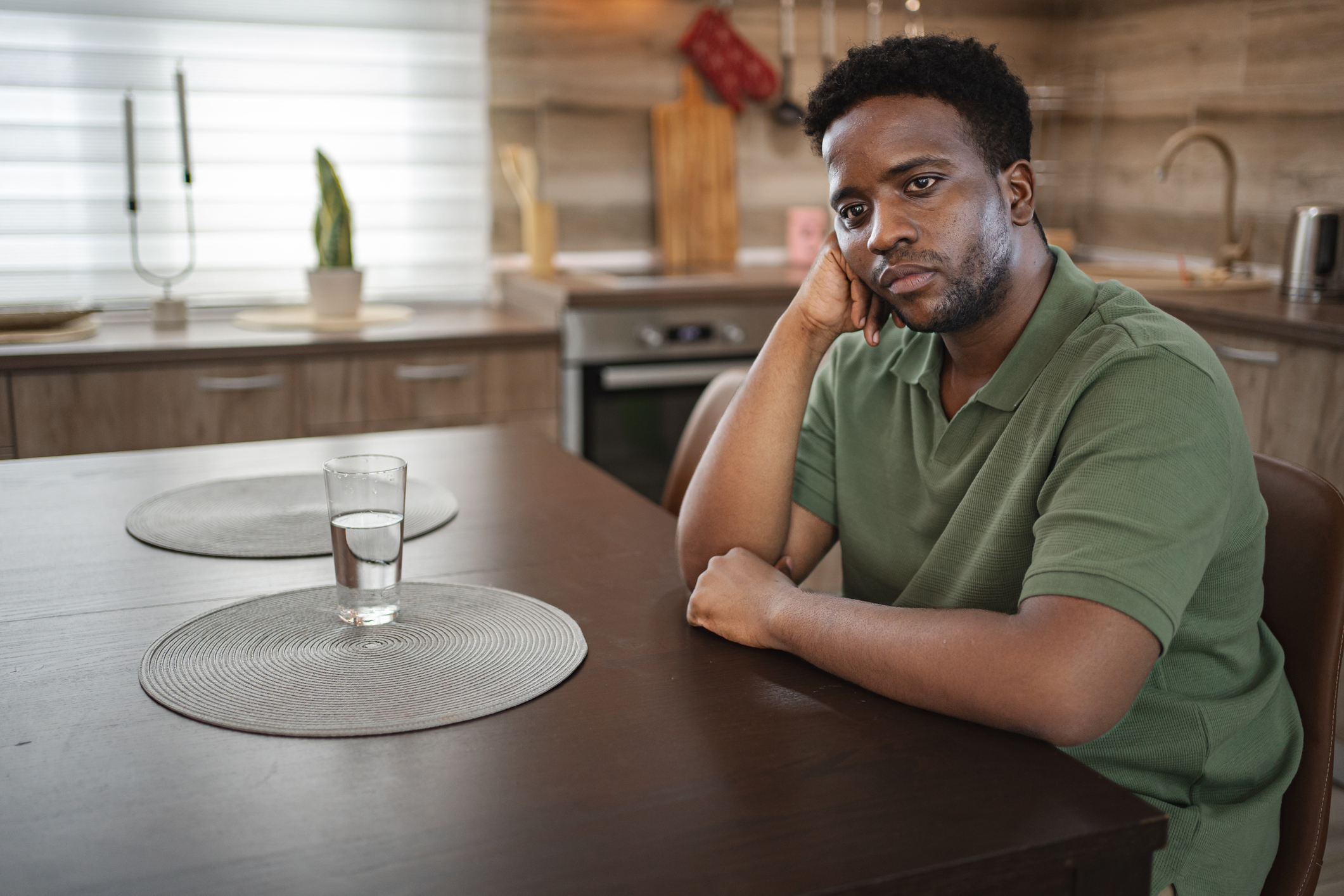Depressed black man sitting at home.