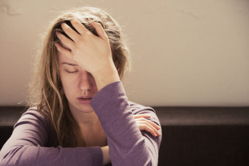 Anxious woman deep in thoughts sitting there working up a sweat.