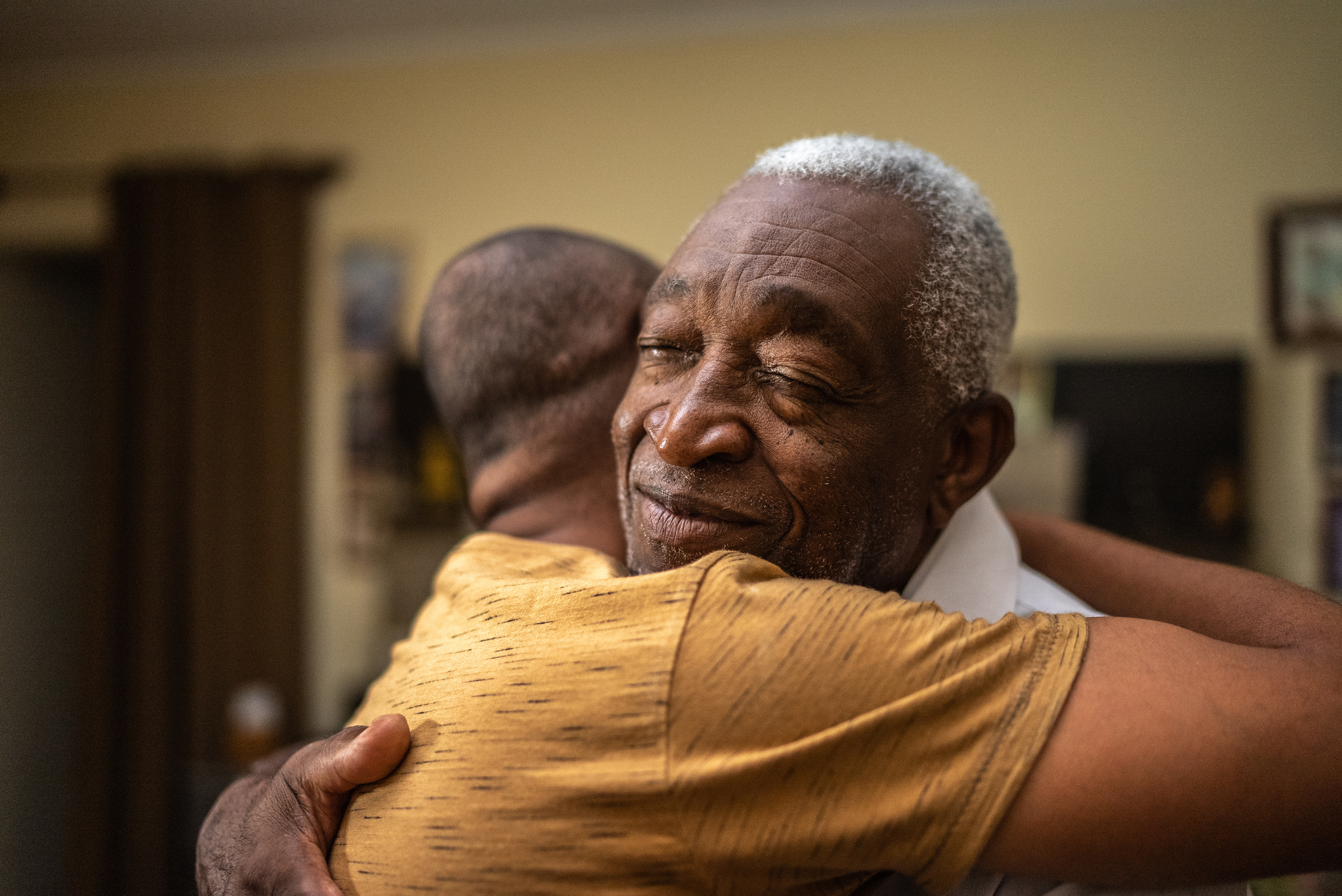 Bonding moment of father and son embracing and giving emotional support at home as son processes his psychosis