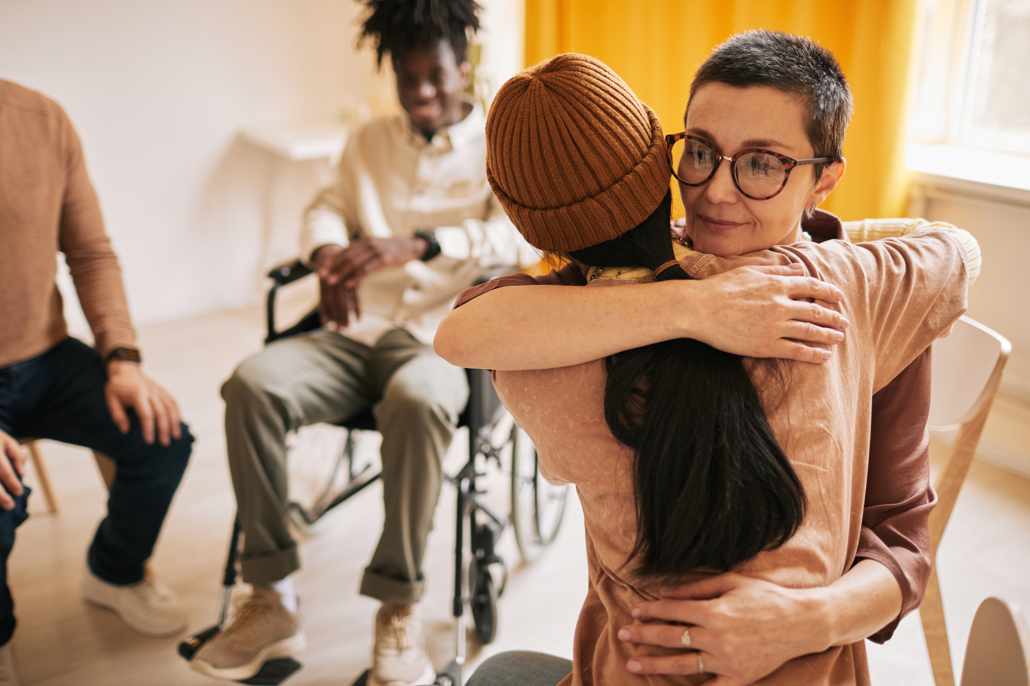 Portrait of women embracing during therapy session in support group about grief