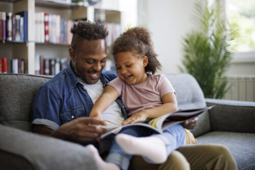 Father and daughter sitting happily together as he offers support for her as a deeply feeling child.