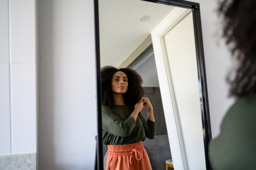Woman looking at herself in the mirror considering if her OCD and eating disorder symptoms are severe.