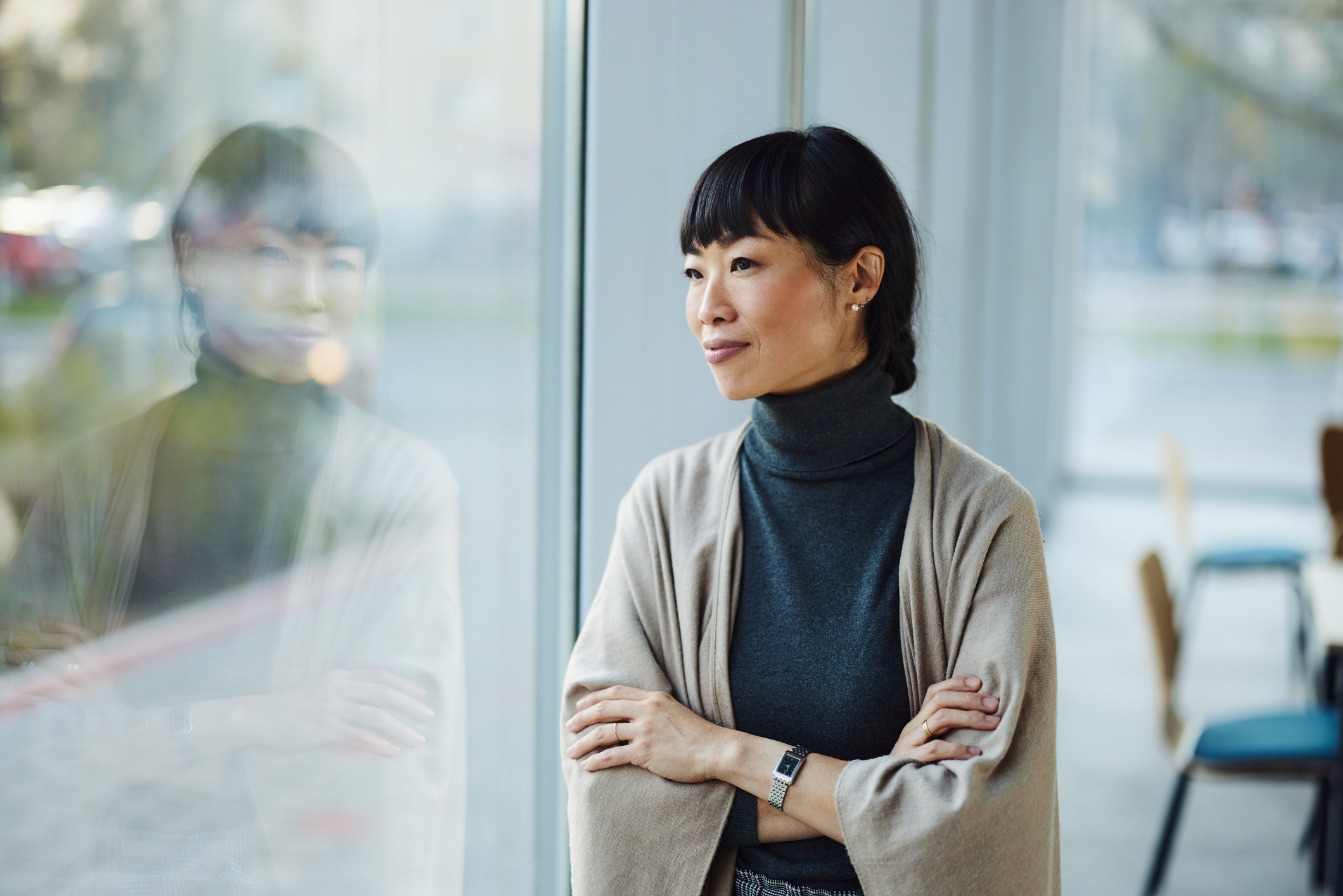 Woman gazing out a window with a thoughtful expression, suggesting reflection or contemplation, often associated with repressed memories