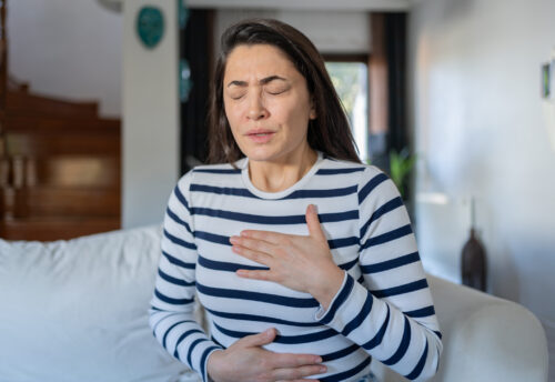 Woman With A Panic Attack Having Trouble Breathing and experiencing chest pain