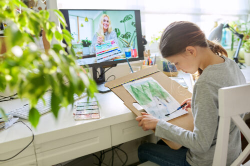 Young girl participating in a virtual art therapy session, challenging the myth that therapy only involves talking and showing how creative approaches can support emotional healing.