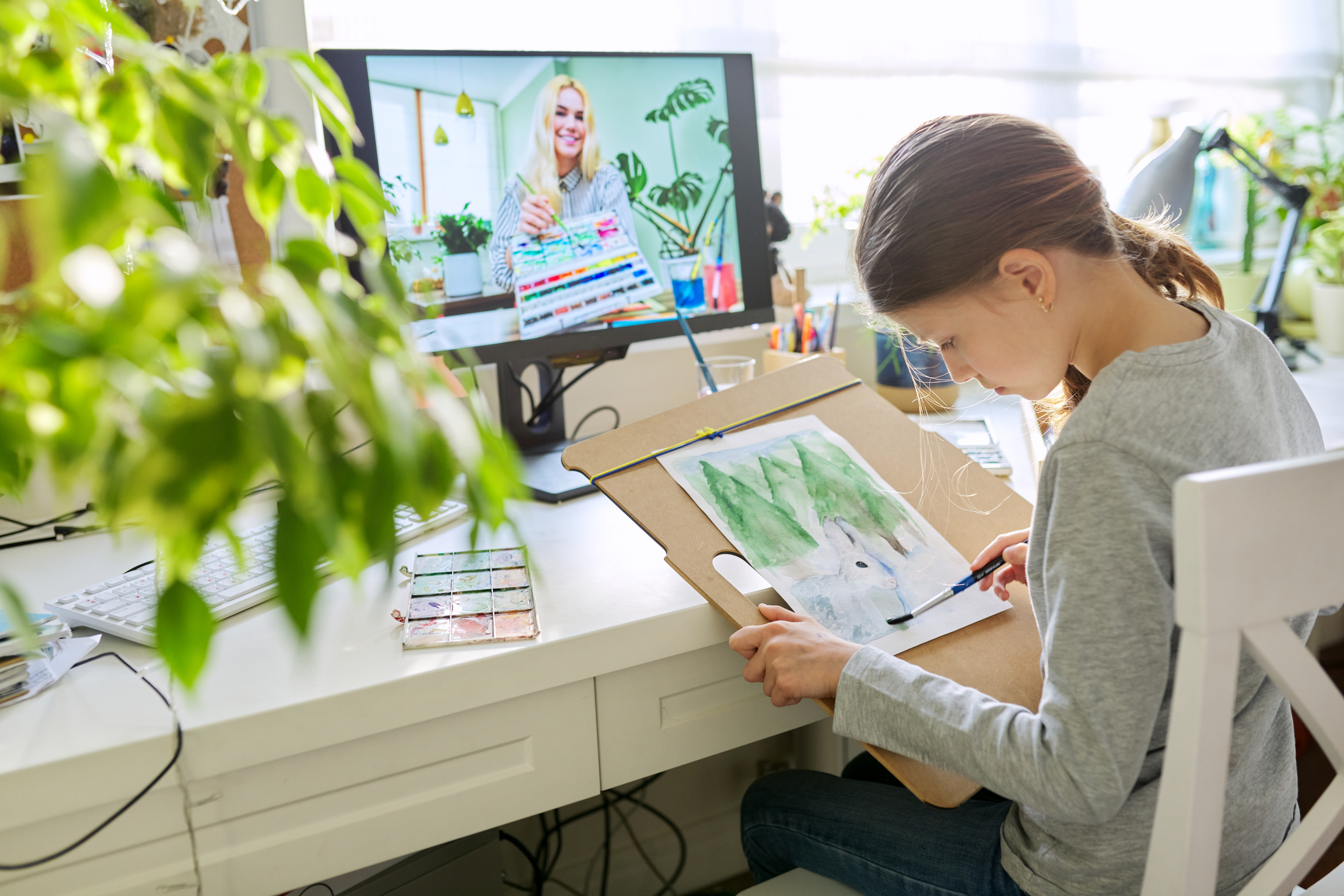 Young girl participating in a virtual art therapy session, challenging the myth that therapy only involves talking and showing how creative approaches can support emotional healing.
