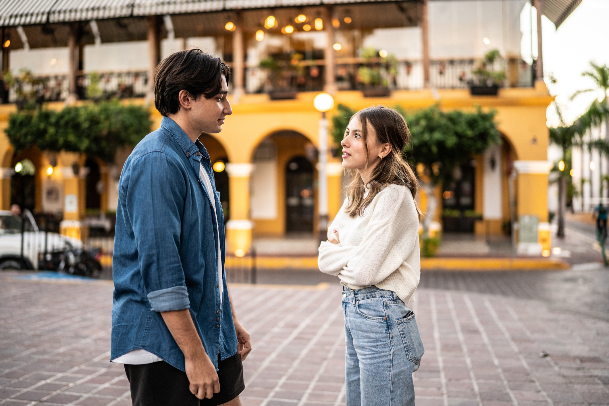 Young couple in a serious conversation outdoors, capturing subtle tension that may signal gaslighting in a narcissistic relationship.