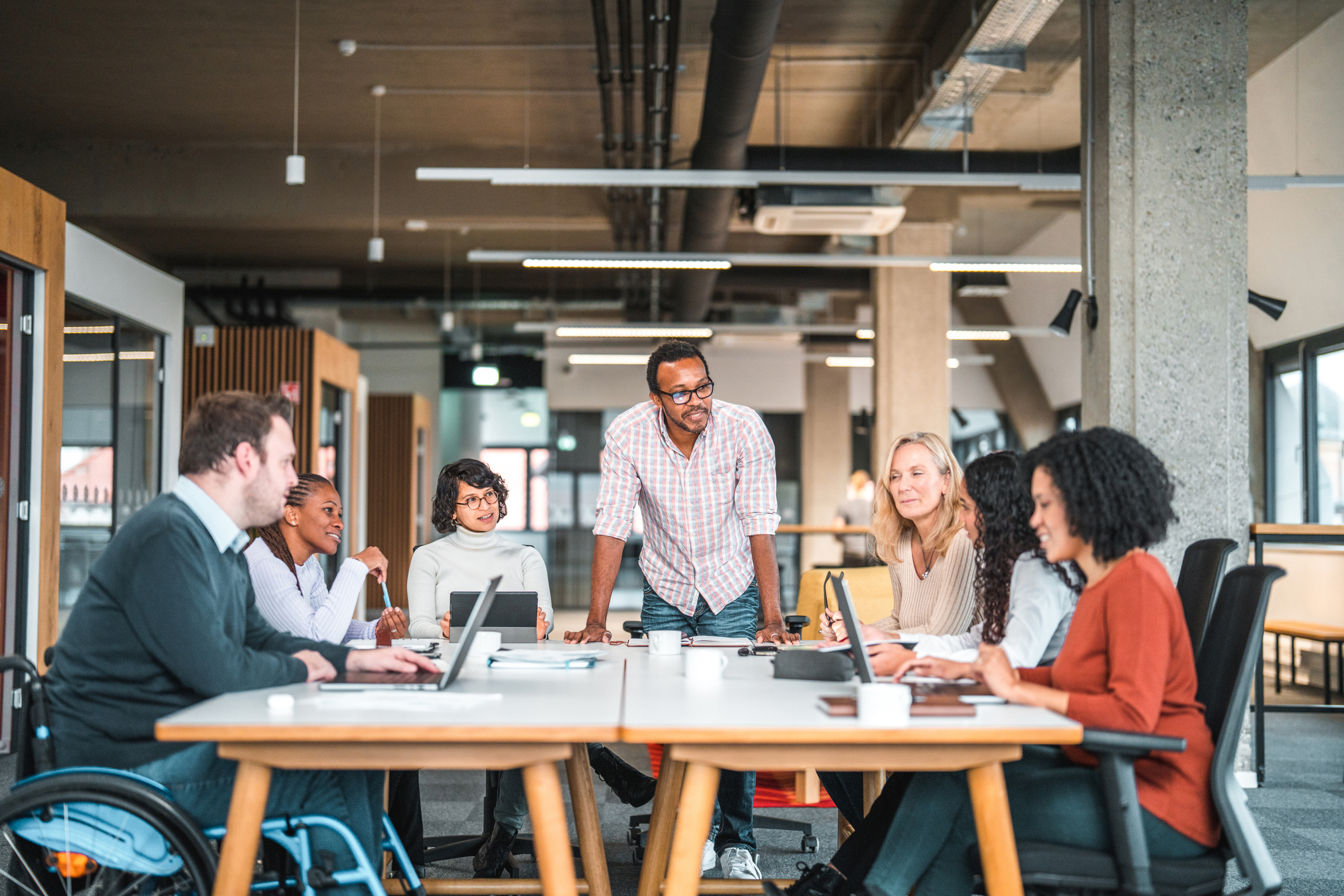 Diverse team collaborating in an office setting, highlighting the importance of structured environments and support for individuals with executive functioning difficulties.