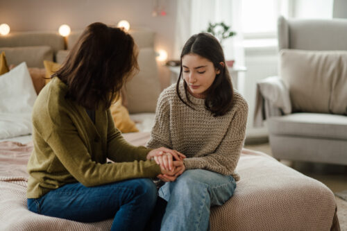 Teen girl receiving emotional support from an adult while dealing with being highly sensitive.
