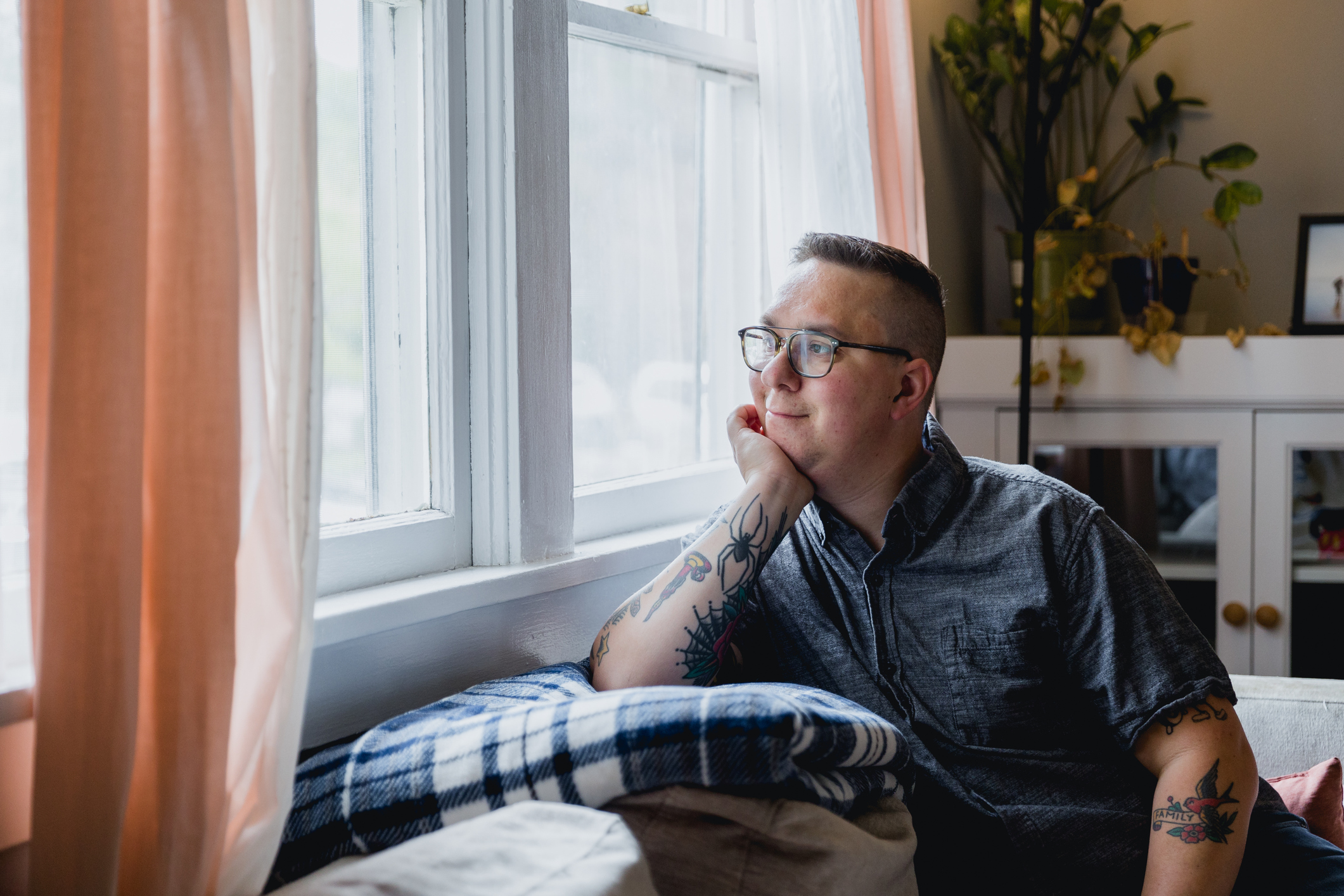 Man gazing out a window peacefully, symbolizing curiosity about inherited traits and the genetic roots of ADHD.