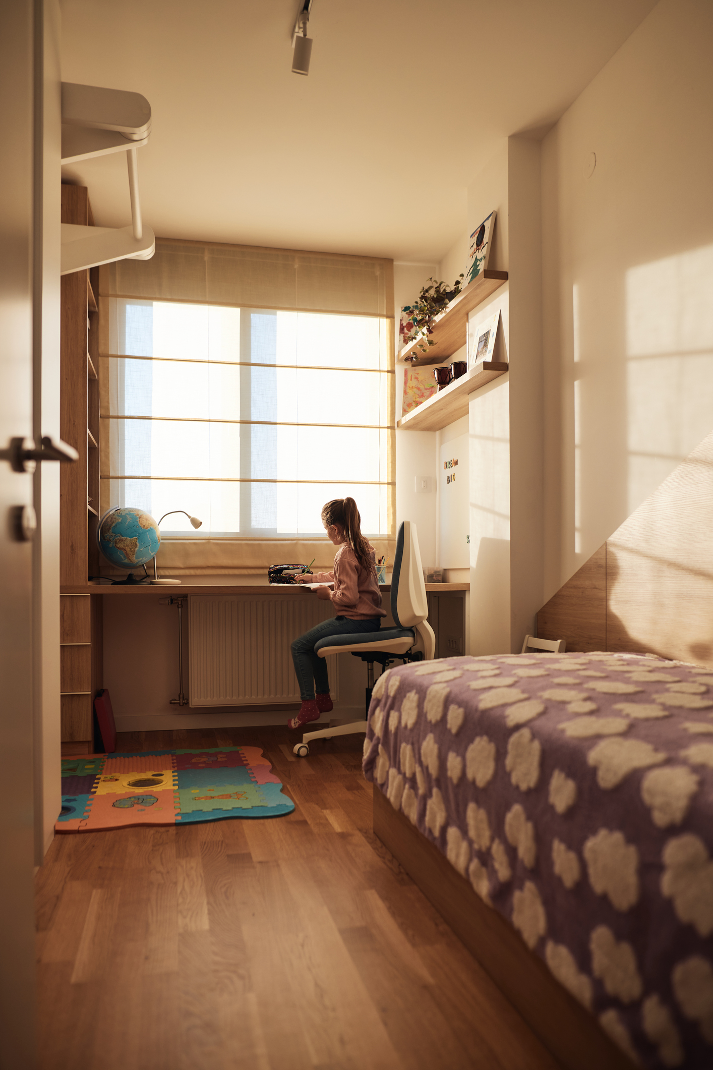 Young girl sitting alone at a tidy desk in her bedroom, reflecting the repetitive behaviors and need for order often associated with childhood OCD.