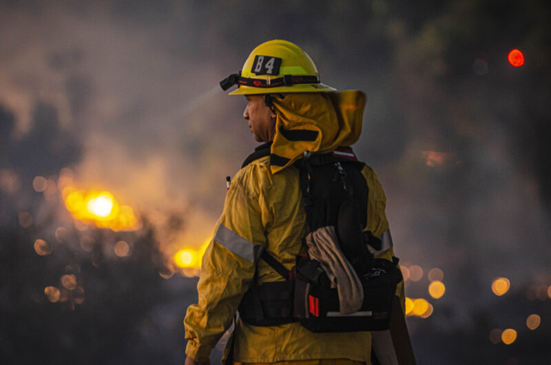 Firefighter facing wildfire, representing strength and coping with mental health challenges on the job.