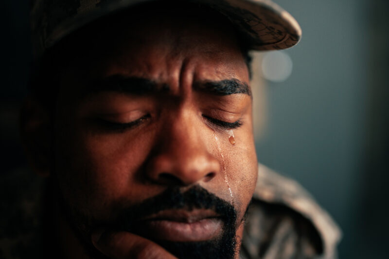 Close-up of man crying with eyes closed, showing the emotional intensity that can accompany anger or frustration.