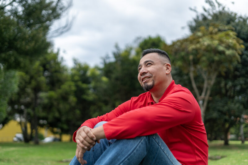 Man smiling in a park, representing improved mood and quality of life associated with low-dose naltrexone treatment.