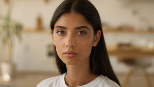 Young woman with a serious expression, symbolizing the emotional impact of mental health stigma, as explored in research on the real effects of stigma.