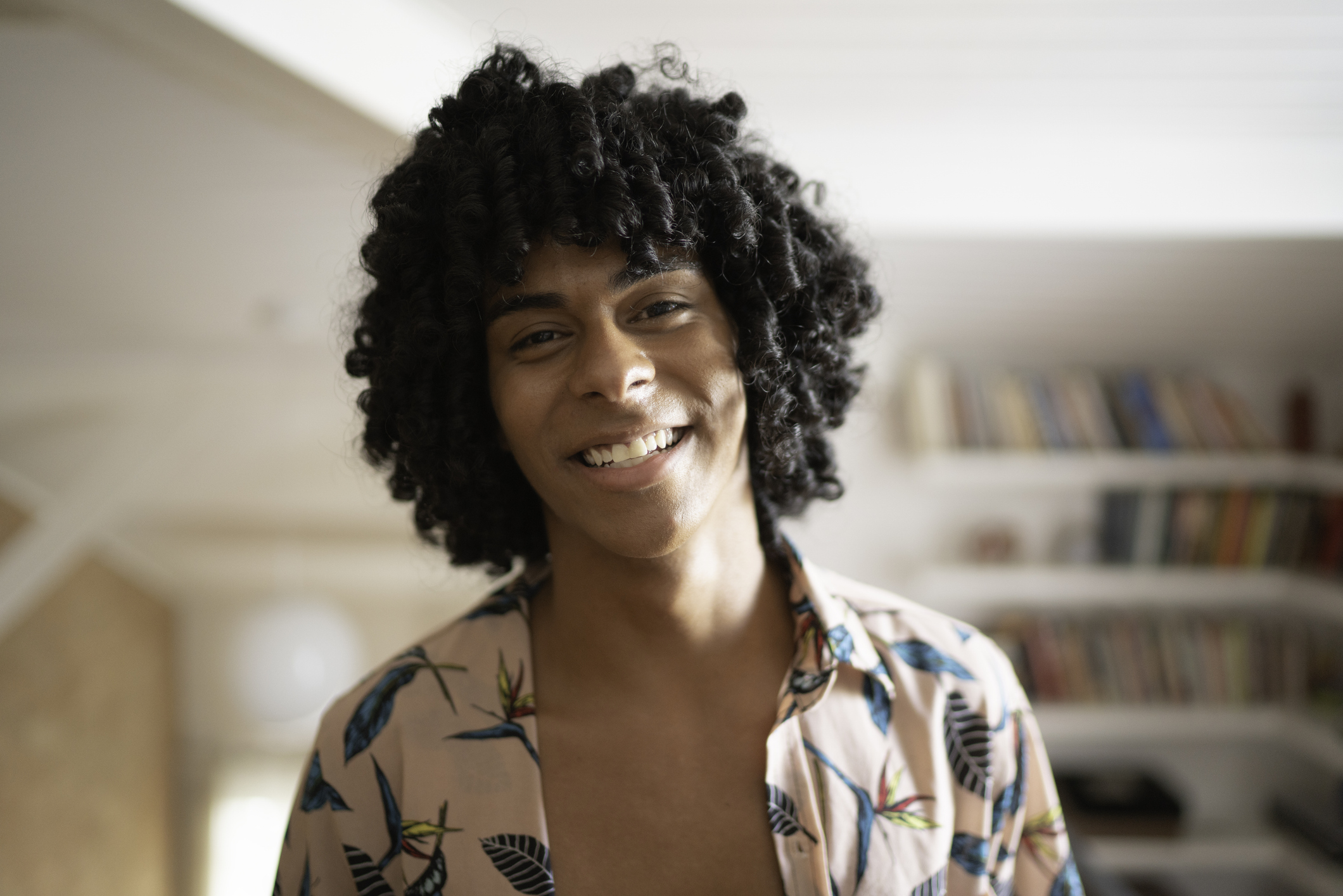 Young adult smiling in a cozy home setting, representing hope and healing through different binge eating disorder treatments recommended by therapists.