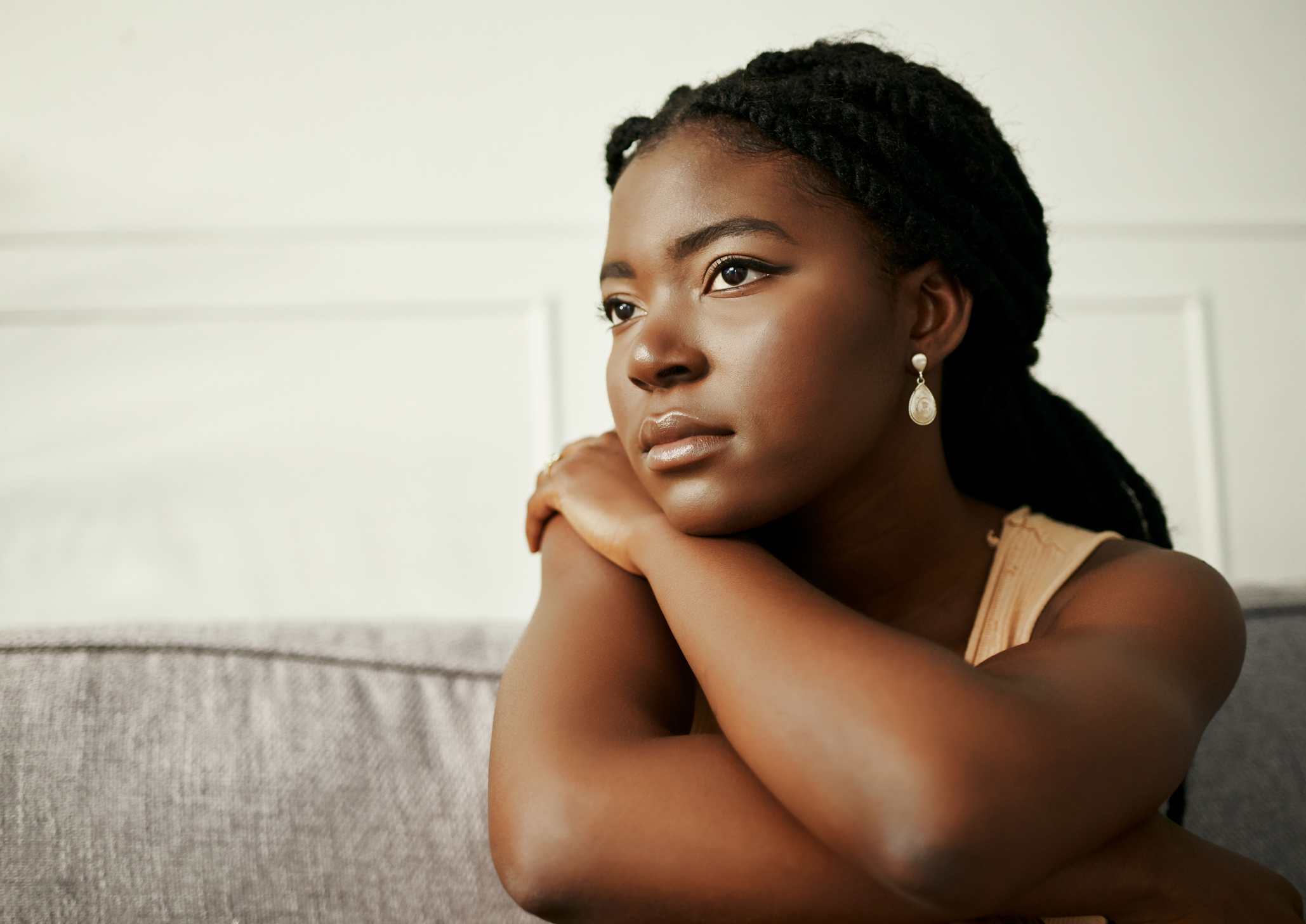 Close-up of a woman staring thoughtfully into the distance with a calm yet somber expression, symbolizing quiet reflection or emotional heaviness.