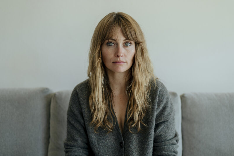 Woman with a neutral expression looking directly at the camera. The image conveys a sense of quiet intensity and emotional depth, reflecting the internal struggles of someone living with high-functioning borderline personality disorder—often masking distress beneath a composed exterior.
