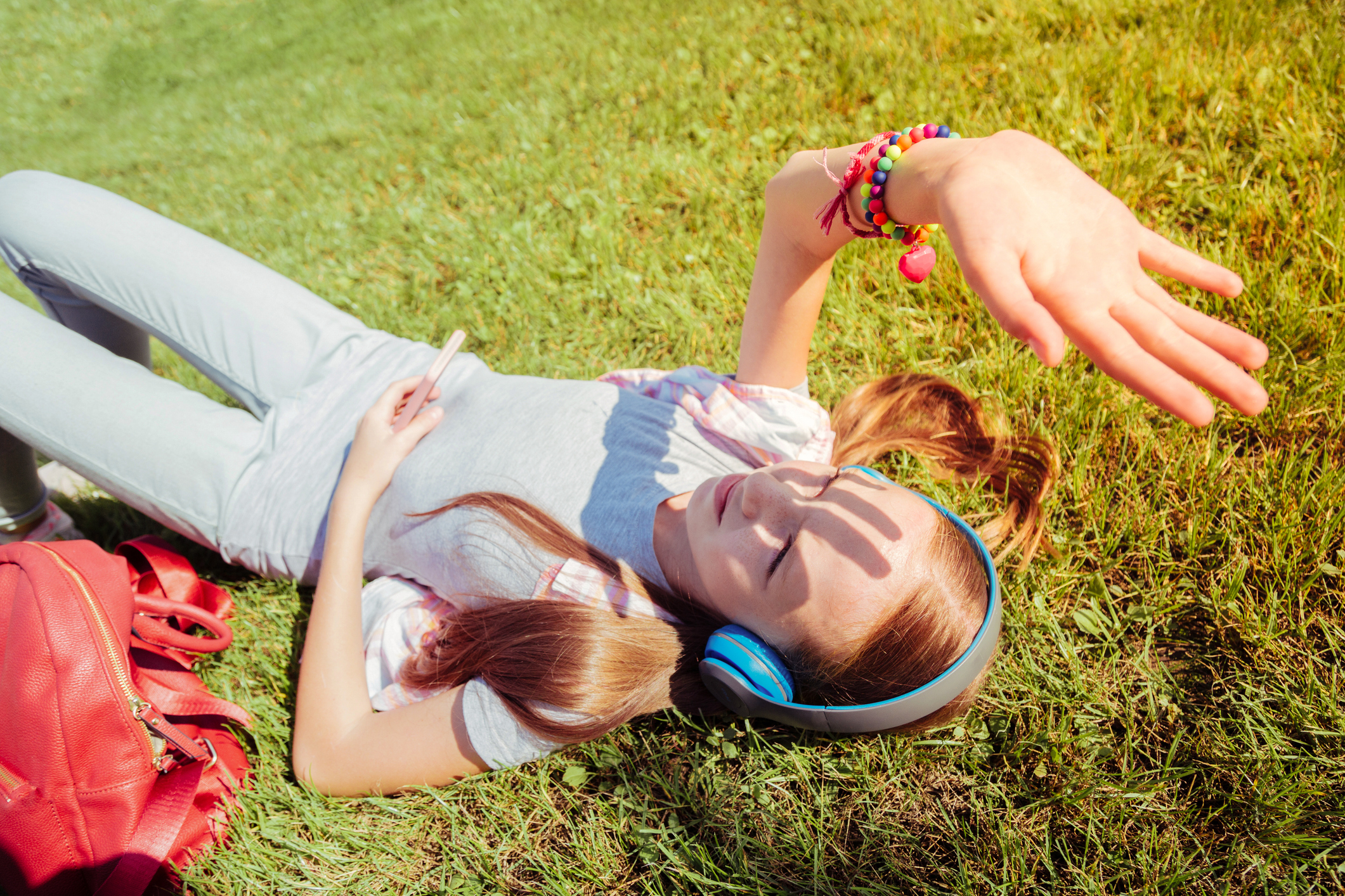 A child looks anxious while staring at her phone, symbolizing the stress and worry that can come with school-related anxiety.