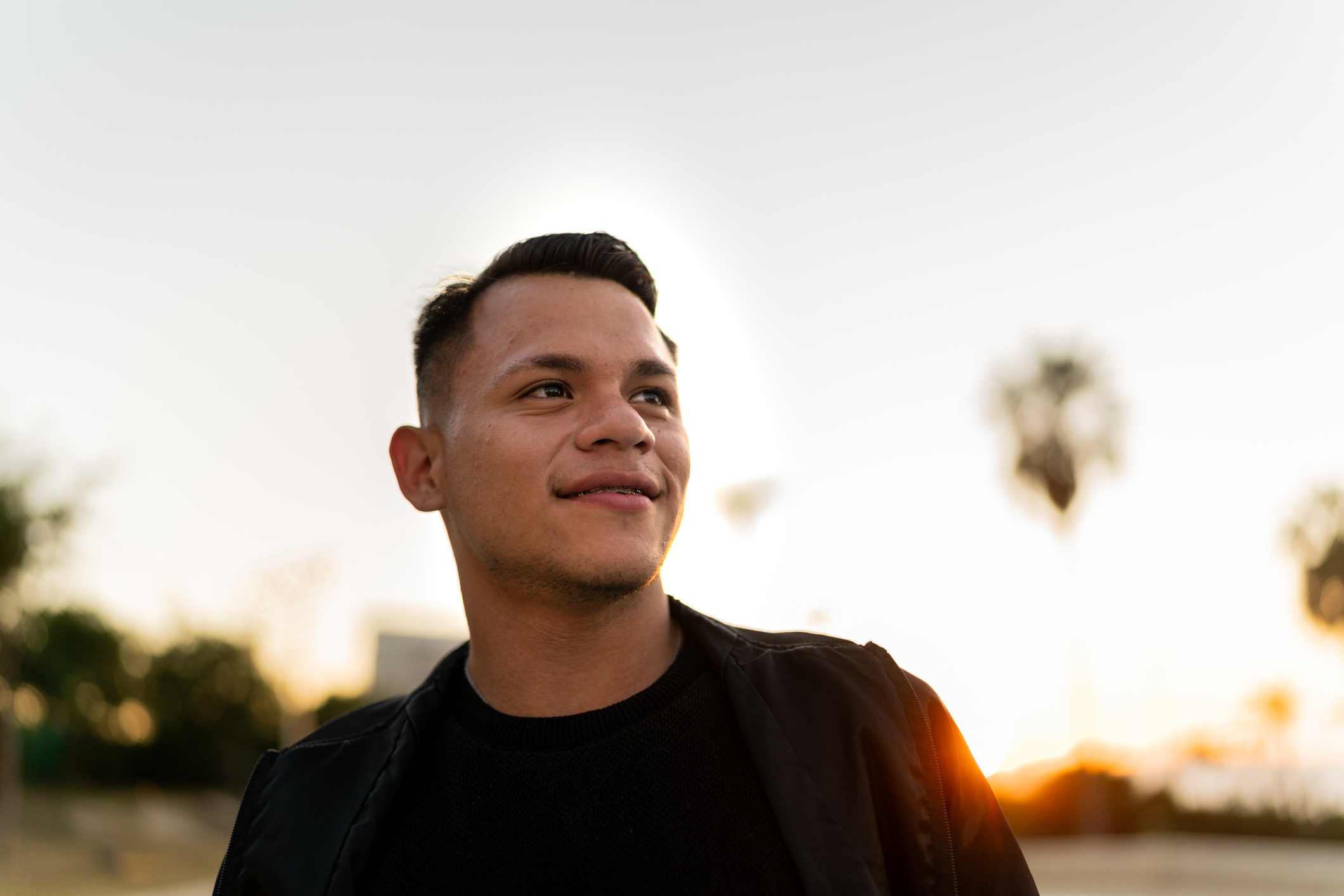 Man smiling with sun behind him suggests clarity, recovery, or contrast between visible wellness and internal disconnection.