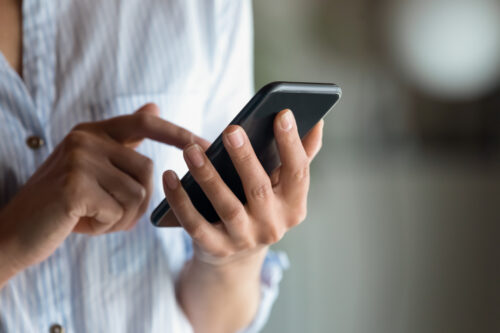 Person using smartphone app to track self-harm recovery and support mental health journey.