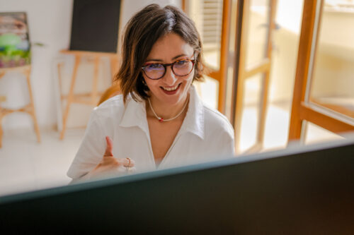 A therapist giving a thumbs-up during a virtual session, illustrating supportive communication and digital therapy note-taking.
