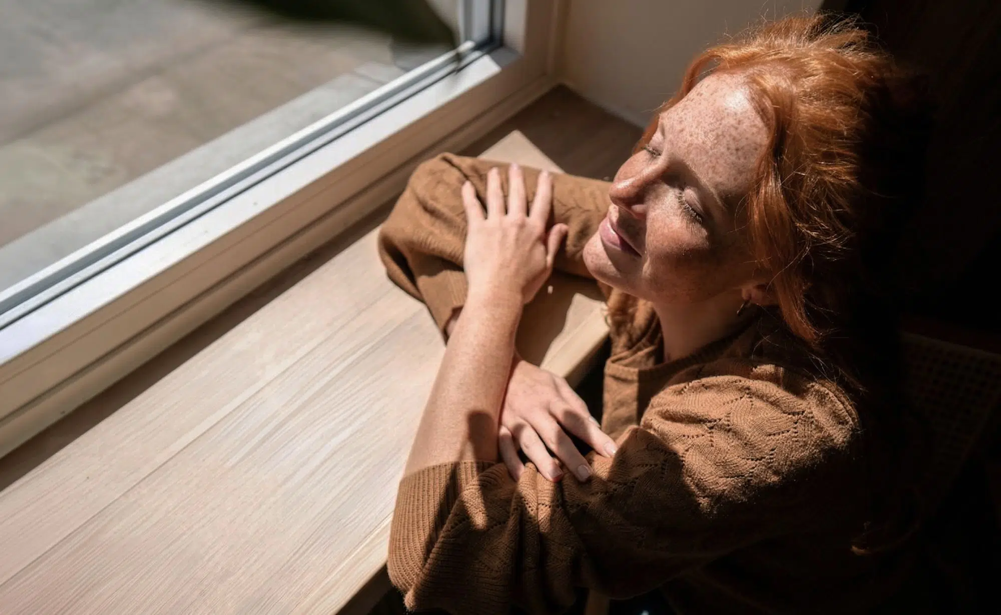 Adult resting in the sun by a window