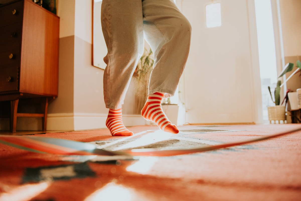 A dancing person, only showing their legs and feet wearing orange socks.