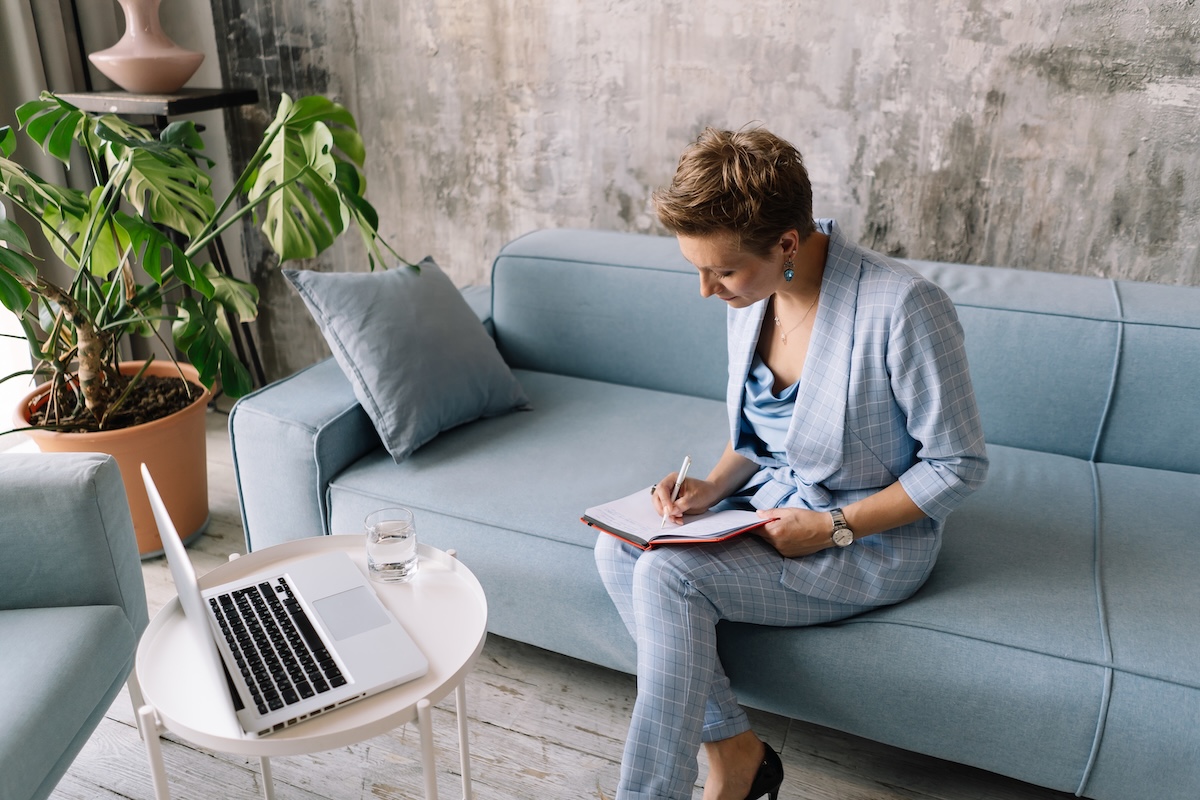 Psychotherapist reviewing notes and a laptop before an online therapy session